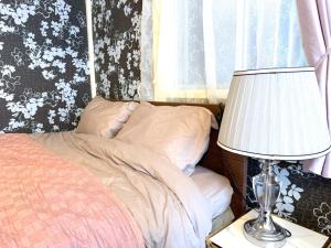 a bedroom with a bed and a lamp on a table at Shinjuku, 3min walk from Nishi-Shinjuku 5-chome Sta, 3min Shinjuku Sta Switch, Wi-Fi ,Pocketwi-Fi in Tokyo