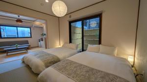 a bedroom with two beds and a window at Dream Stays SORA in Izumi-Sano