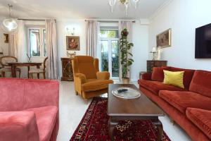 ヴィリニュスにあるLuxury Old Town Apartment with Terraceのリビングルーム(赤いソファ、テーブル付)