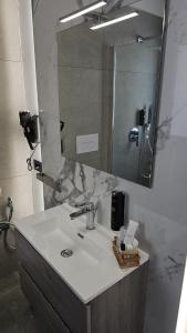 a bathroom with a sink and a large mirror at Panhouse Rooms & Suite in Palermo +89 photos
