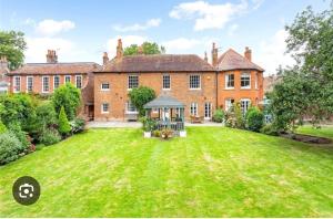 an exterior view of a large brick house with a yard at Dream Lodge in Stanwell