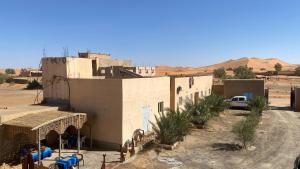 a building in the middle of a desert at Tifinagh Guest House in Merzouga