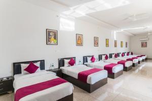 a row of beds in a white room with red pillows at BA-NA Hills Resort in Salara +37 photos