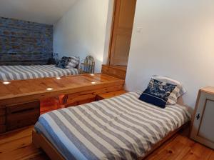 a room with two beds and a wooden table at Chez Suzon in Auzon