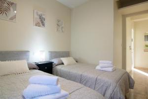 a room with two beds with towels on them at Apartamento LUNADA I in Candeleda