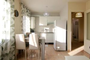a kitchen with a table and a white refrigerator at Apartamento LUNADA I in Candeleda