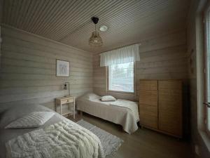 a bedroom with two beds and a window at Auhon sarastus - Dream by a lake in Petäjä