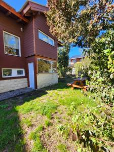 ビージャ・ラ・アンゴストゥーラにあるCasa Sukha ALOJAMIENTOS PATAGONICOSの庭のピクニックテーブル付き家