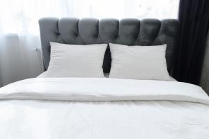 ein Bett mit weißen Laken und Kissen in einem Schlafzimmer in der Unterkunft Baltic Serenity - SELF CHECK-IN in Klaipėda