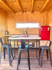 a kitchen with a table and chairs and a red refrigerator at Tiny house & SpA, casa de encuentros in La Ligua