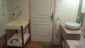 a bathroom with a sink and a white door at Maison rénové en pierre in Crotenay +42 photos
