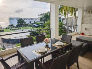 Un comedor con mesa y sillas en un balcón. en Karon Beach Large 2 bedrooms & living room Seaview apartment, en Ka Rorn