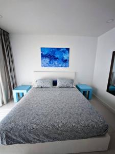 Un dormitorio con una cama y dos mesas azules. en Karon Beach Large 2 bedrooms & living room Seaview apartment, en Ka Rorn 40 fotos más