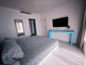 Un dormitorio con una cama y un televisor de pantalla plana. en Karon Beach Large 2 bedrooms & living room Seaview apartment, en Ka Rorn