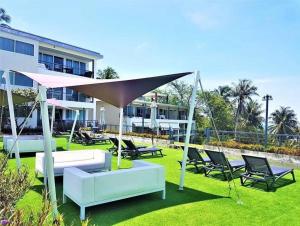 Un grupo de sillas y mesas frente a un edificio. en Karon Beach Large 2 bedrooms & living room Seaview apartment, en Ka Rorn