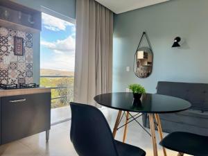 a dining room with a table and a large window at Flat Jade - Alto Paraíso - Chapada dos Veadeiros in Alto Paraíso de Goiás +14 photos