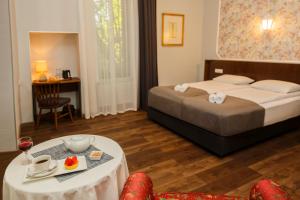 una camera d'albergo con un letto e un tavolo con un piatto di cibo di Tea for Two Hotel a Tbilisi City
