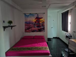 a bedroom with a pink bed with a painting on the wall at Jay Jay Guesthouse in Bangkok +5 photos