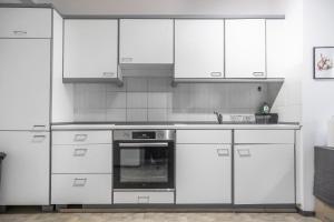 a kitchen with white cabinets and a stove top oven at Oldtown Apartments by StayStay, close to Castle & Main Market Square in Nürnberg