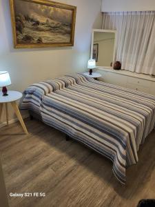 a bed in a bedroom with a striped bedspread at FULLY RENOVATED APT BY THE OCEAN in Punta del Este