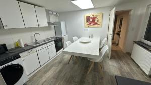 a white kitchen with a white table and chairs at KüstenNest gepflegte großzügige Ferienwohnung Nähe Ostsee mit Garten in Ratekau