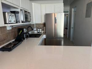 a kitchen with a refrigerator and a counter top at Aguada Beach Condos in Aguada