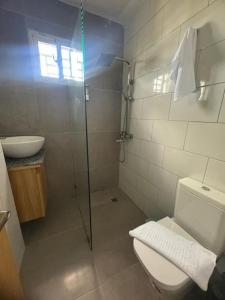 a bathroom with a toilet and a glass shower at Apartamento santo domingo este in Juan López