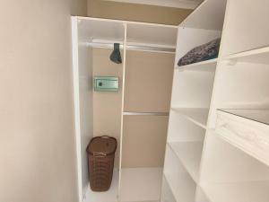 - un dressing avec des étagères blanches dans l'établissement Weaver's Corner Richards Bay, à Richards Bay