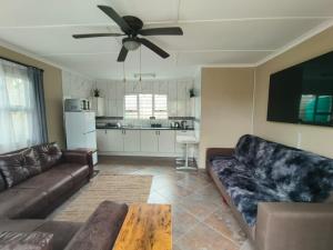 un salon avec un canapé et un ventilateur de plafond dans l'établissement Weaver's Corner Richards Bay, à Richards Bay