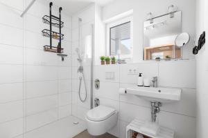 a white bathroom with a toilet and a sink at Maltes-Ostseekoje Parken frei vorm Haus, 500m zum Strand,Infrarotsauna,Magenta TV mit Netflix ,Disney TVund Rtl plus, Kaminofen im Wohnzimmer,ab Oktober Brennholz gratis Fahrradschuppen,Mückenschutz in Olpenitz +28 photos
