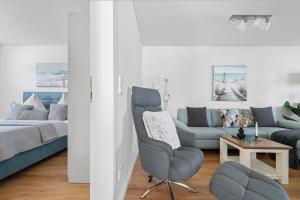 a living room with a couch and a chair at Maltes-Ostseekoje Parken frei vorm Haus, 500m zum Strand,Infrarotsauna,Magenta TV mit Netflix ,Disney TVund Rtl plus, Kaminofen im Wohnzimmer,ab Oktober Brennholz gratis Fahrradschuppen,Mückenschutz in Olpenitz