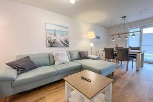 a living room with a couch and a table at Maltes-Ostseekoje Parken frei vorm Haus, 500m zum Strand,Infrarotsauna,Magenta TV mit Netflix ,Disney TVund Rtl plus, Kaminofen im Wohnzimmer,ab Oktober Brennholz gratis Fahrradschuppen,Mückenschutz in Olpenitz