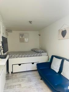 Un dormitorio con una cama y un sofá azul. en SteR Appartement Zandvoort, en Zandvoort
