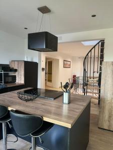 eine Küche mit einer Holzinsel mit Stühlen in der Unterkunft Casa Majorelle - Maison spacieuse et élégante in Montigny-lès-Metz