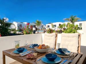 a wooden table with a bowl of fruit on it at Fuerte Calma Luxury Apartment Fuerteventura in La Oliva
