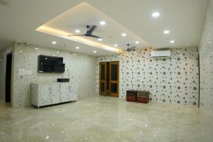 a living room with a ceiling fan and a tv at Akshayaa Grand in Visakhapatnam