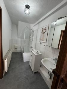 a bathroom with a tub and a sink and a bath tub at Erzgebirgsglück Jöhstadt EG in Jöhstadt