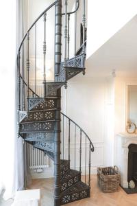 a spiral staircase in a living room with a fireplace at MEERBLICK-MAISONETTE Ostseebad Kühlungsborn in Kühlungsborn