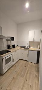 eine Küche mit weißen Schränken und einem Holzboden in der Unterkunft Monteurwohnung Ferienwohnung Krefeld Nähe Düsseldorf 2-4 Personen in Krefeld + 20 Fotos