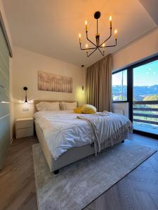 a bedroom with a large bed and a chandelier at Greg Rooms in Sinaia
