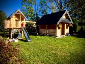 a playground with a slide and a play house at Noclegi u Masnych in Witów