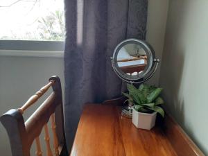 a mirror on top of a wooden table next to a window at The Loft in Mtunzini