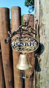 a bell is attached to a wooden fence at 4 Elementos Guest House in Arraial d'Ajuda