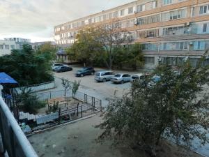 a parking lot with cars parked in front of a building at 20 дом у моря in Aktau