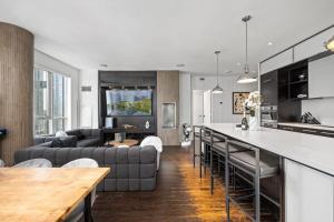a kitchen and living room with a couch and a table at PARC LOFT Penthouse with 4bd-WFH-PS5-CN Tower Views in Toronto
