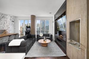 a living room with a couch and a tv at PARC LOFT Penthouse with 4bd-WFH-PS5-CN Tower Views in Toronto