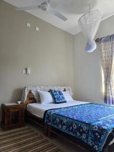 a bedroom with a bed with a blue comforter at The Vipingo Retreat in Vipingo +55 photos