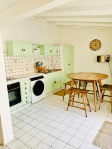 a kitchen with green cabinets and a wooden table at Appartement les Amandines - Centre ville Sainte Anne in Sainte-Anne