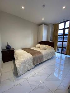 a bedroom with a bed on a white tiled floor at Casa Centro Histórico Cuenca in Cuenca