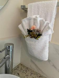 a towel holder with flowers on the corner of a bathroom at Casa Centro Histórico Cuenca in Cuenca